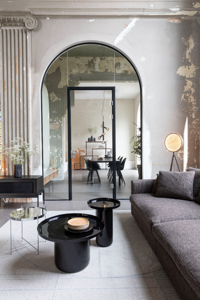 Industrial-style living room with arched doorway and dining area