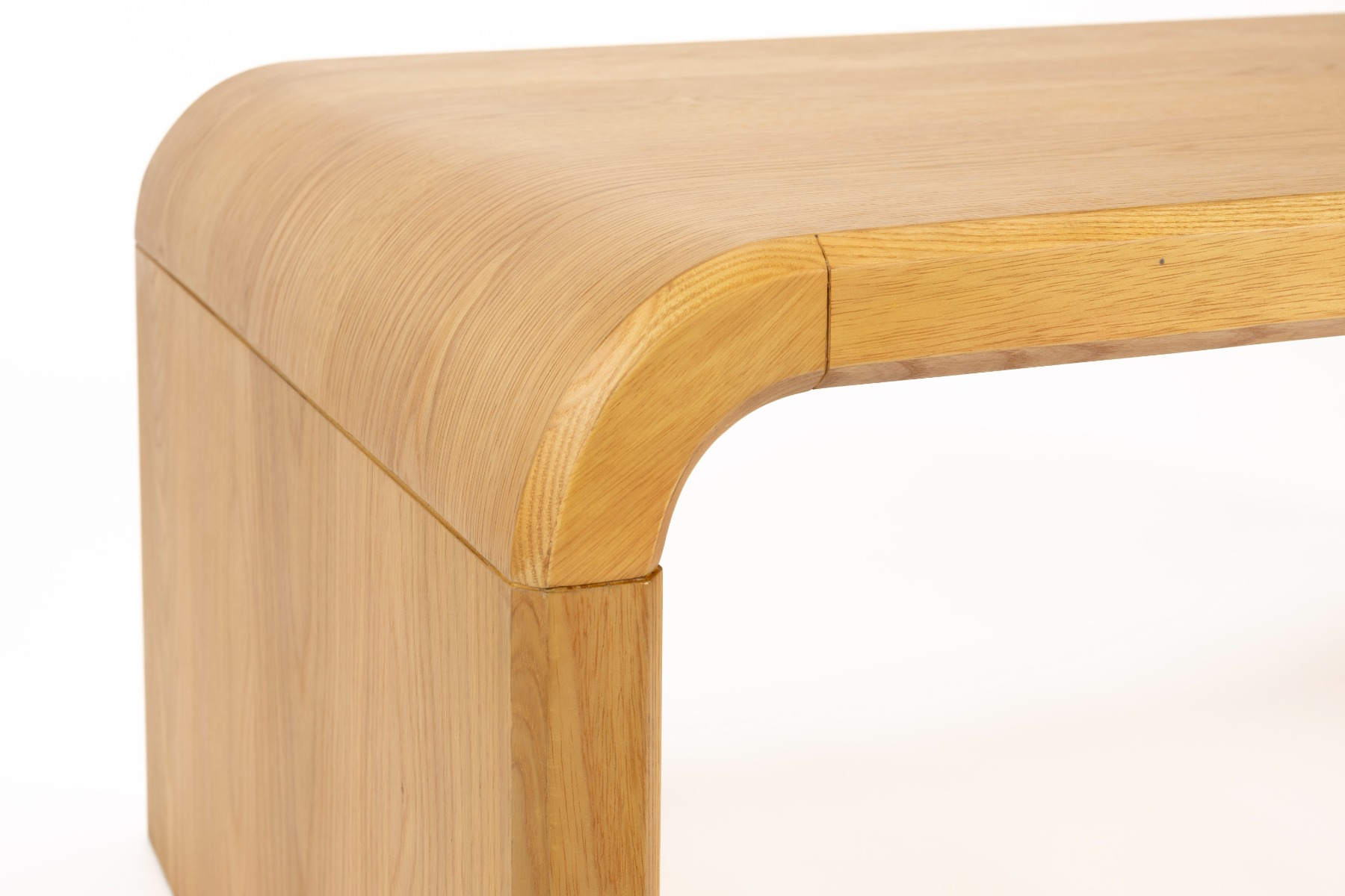 A wooden bench or coffee table with curved ends and a simple, modern design, shown against a white background.